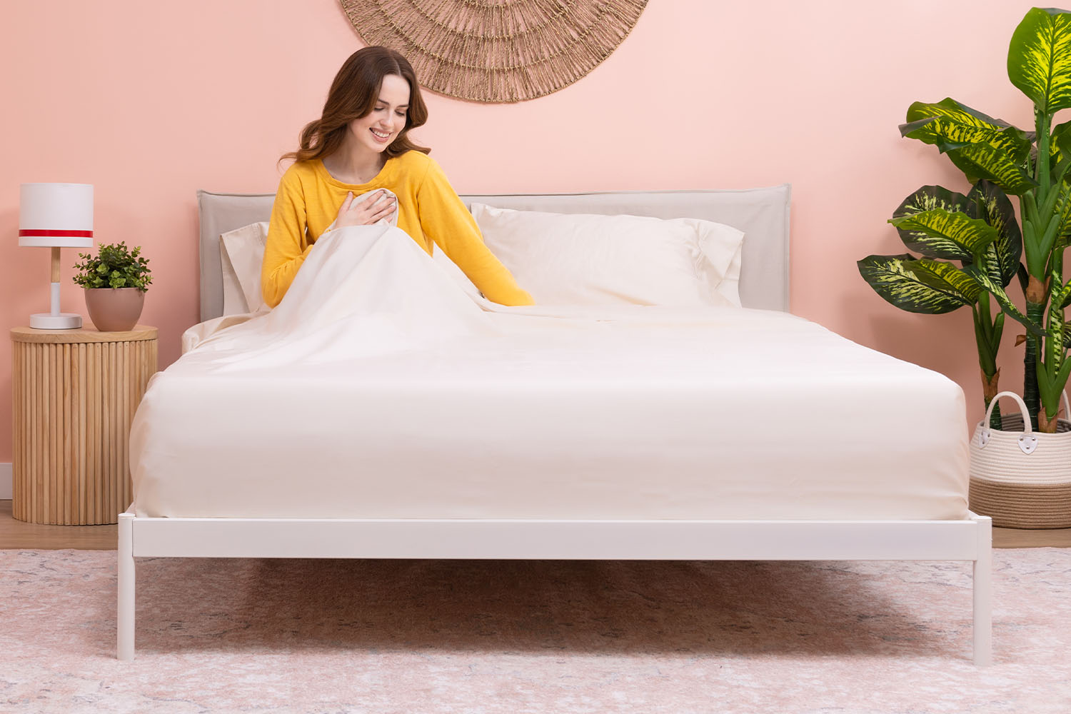 Femme assise dans son lit et touchant ses draps en coton égyptien Douglas